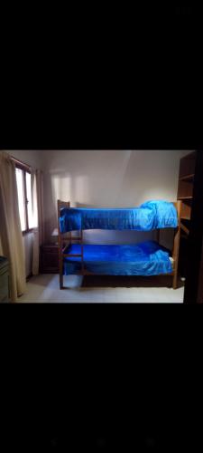 a bed with a blue blanket on it in a room at Vida nada me debes in Ostende