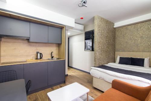 a hotel room with a bed and a kitchen at Nomad Hub Suit İstanbul in Istanbul