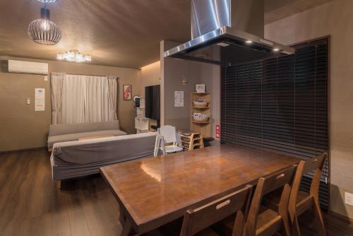 a kitchen and living room with a table and a couch at Noctis豊田 ジャグジー肩湯付お風呂75型TV 最大12名宿泊可能 in Toyota