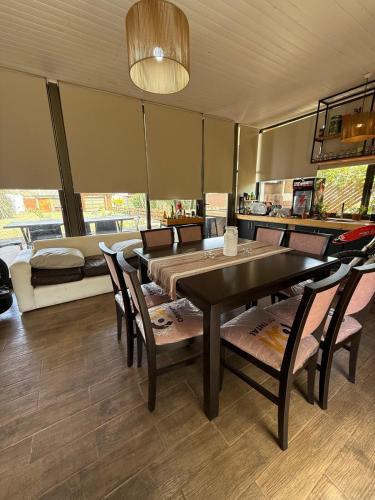 a dining room with a table and chairs and a couch at Loft moderno con cocina americana y vistas a la montaña in Belén