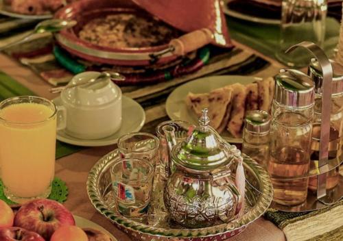 una mesa cubierta con platos de comida y una tetera en Hayati Desert Luxury Camp, en Merzouga