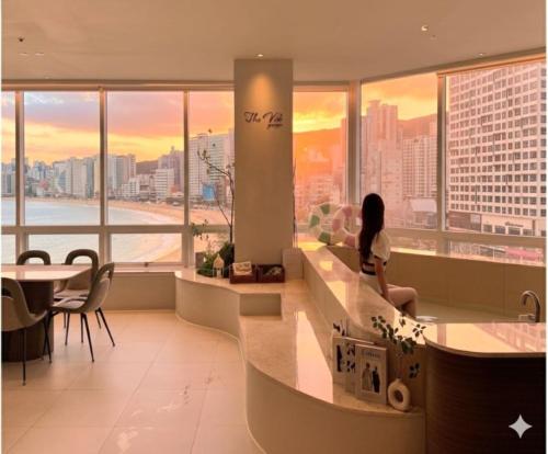 a woman sitting on a counter in a building at TheVibe Gwangan-Grand Oceanview Private Villa in Kwangan-dong