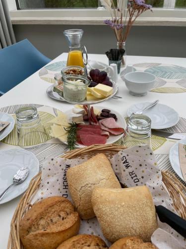 een tafel met een bord brood en andere voedingsmiddelen bij Pension Freudenthal in Wandersleben