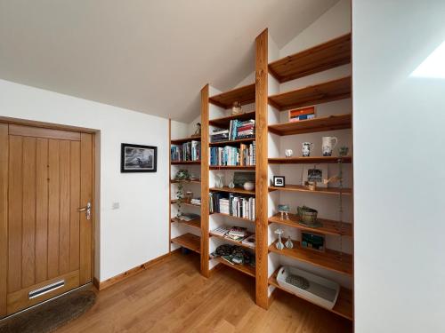 ein Raum mit Holzregalen mit Büchern in der Unterkunft Shamerbrea The Foodie B&B in Inverness