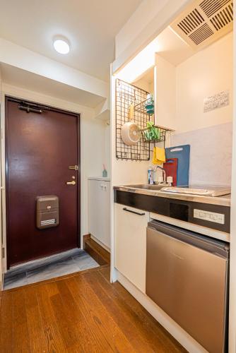 a kitchen with a brown door and a sink at sakura 303 in Tokyo
