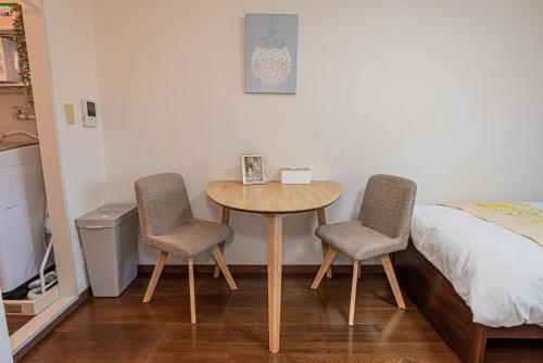 a room with a table and two chairs and a bed at sakura 303 in Tokyo