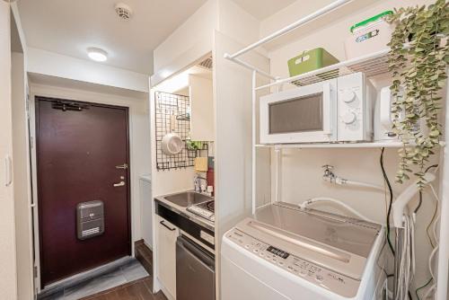 a small kitchen with a sink and a microwave at sakura 303 in Tokyo