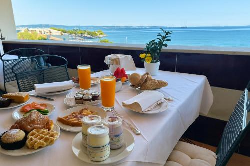 een tafel met ontbijtproducten en sinaasappelsap erop bij Panorama Apartment in Trieste