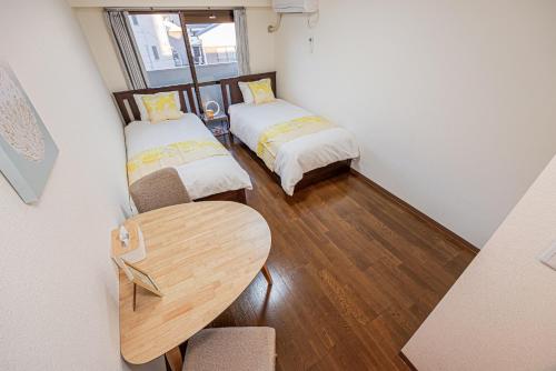 a small room with two beds and a table at sakura 303 in Tokyo