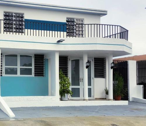 a blue and white house with a balcony at Daisy'Hause 2 to 6 people, ideal for your family in Carolina