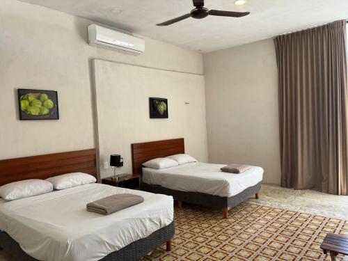 a hotel room with two beds and a ceiling fan at Hotel Don Abel Champotón in Champotón