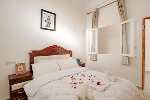 a bedroom with a bed with red rose petals on it at Retraite Panoramique sur l'Atlas in Ourika