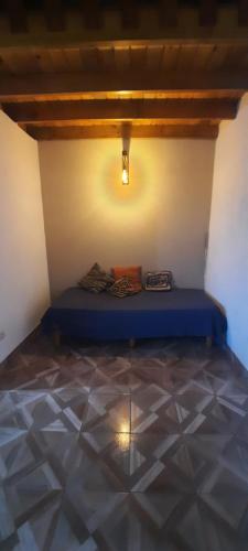 a bedroom with a blue bed in a room with a tiled floor at La curva del molino in Villa Parque Siquiman