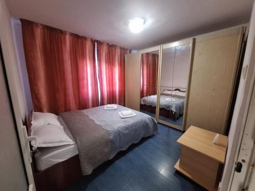 ein kleines Zimmer mit einem Bett und einem Spiegel in der Unterkunft ApartamentG4 in Craiova