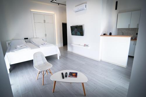 een slaapkamer met een bed, een tafel en een stoel bij Old Town Pearl Apartments in Sarajevo