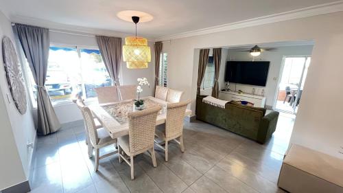 a dining room with a table and chairs and a television at Villa Dominique in Villas del Mar