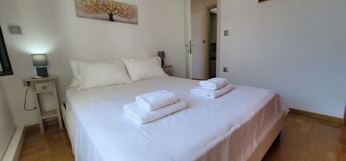a bedroom with a white bed with towels on it at Harmony Apartment Pythagoreio Samos Center in Pythagoreio