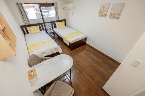 a small room with two beds and a table at sakura 403 in Tokyo
