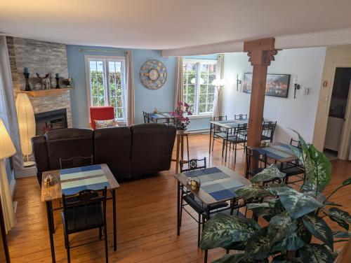 sala de estar con sofás, mesas y chimenea en Au Saut Du Lit, en Magog-Orford