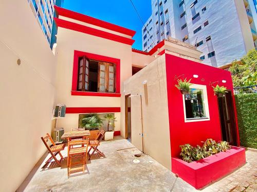 a red house with chairs and a table in a courtyard at Pousada Solana in Salvador