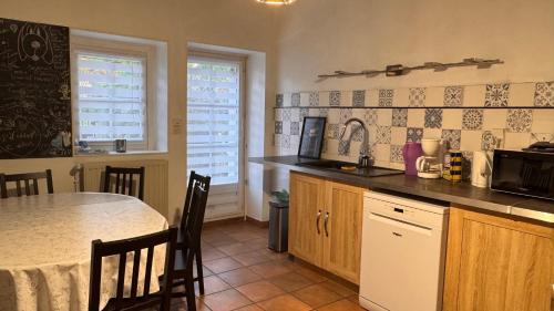 une cuisine avec une table et un comptoir dans l'établissement Maison 110 m2 - 3 chambres - 7 couchages - 5 min Dole, à Champvans