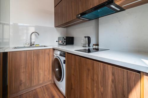 a kitchen with a washing machine and a sink at HNT Homestay Đào Tấn - Near Lotte Center in Hanoi
