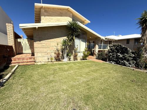 a house with a large lawn in front of it at 24 Sorrento Seabreeze 5br Family Seaside Home in Perth