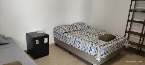 イタニャエンにあるPousada Espaço Vista Marの小さなベッドルーム(ベッド1台、棚付)