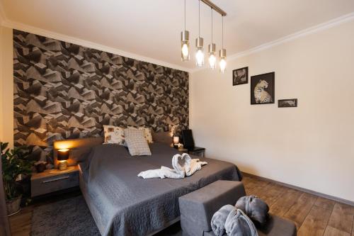 een slaapkamer met een bed in een kamer met een muur bij Csillag Vendégház Mórahalom in Mórahalom