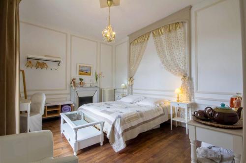 a bedroom with a bed and a table and a window at Villa de charme, 15 personnes, vue canal in Rohan