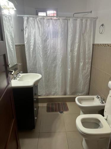 a bathroom with a sink and a toilet and a shower at Alquilo Casa Miramar in Miramar