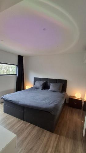 a bedroom with a large bed with a large ceiling at Vichte groundfloor apartment 