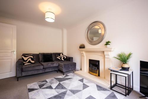 ein Wohnzimmer mit Couch und Kamin in der Unterkunft Brook - Sizewell - Contractor Accommodation in Saxmundham