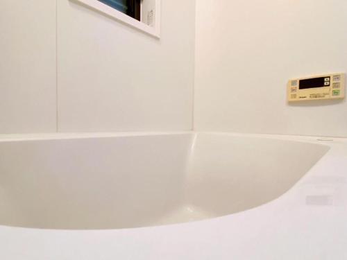 a white counter with a clock on a wall at Poppy ikebukuro in Wada