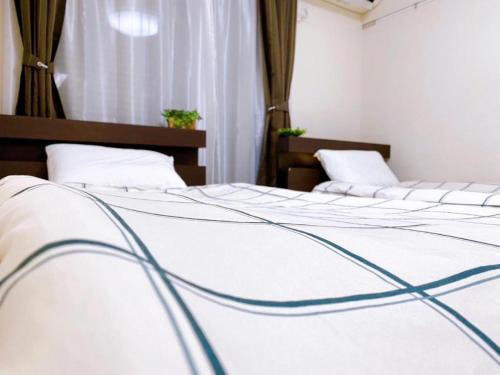 a couple of beds in a room at Poppy ikebukuro in Wada