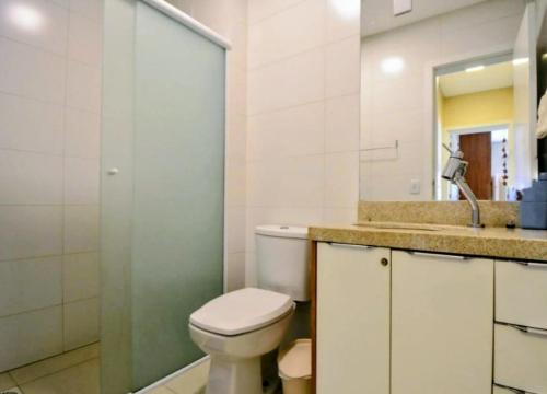 ein Badezimmer mit Toilette, Waschbecken und Spiegel in der Unterkunft Spazio di Patricia in Governador Celso Ramos