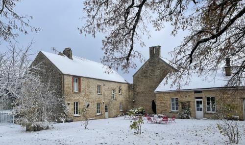 a large brick building with snow on the ground at La Closerie de Gigny Maison Templiere avec Piscine,jacuzzi in Gigny