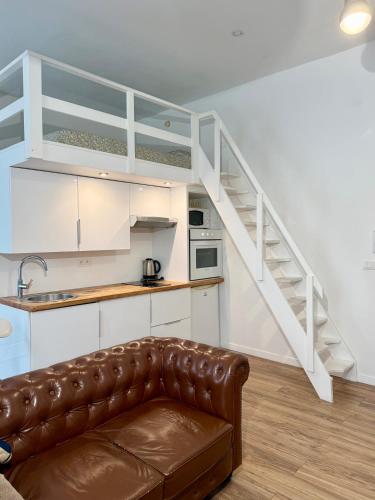 un salon avec un canapé et un escalier dans l'établissement Appartement central, à Nice
