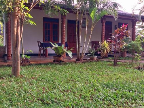 a house with a porch with palm trees at Green Lake Sigiriya in Sigiriya