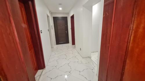 a hallway with a white tile floor and a door at Ramela in Dakar