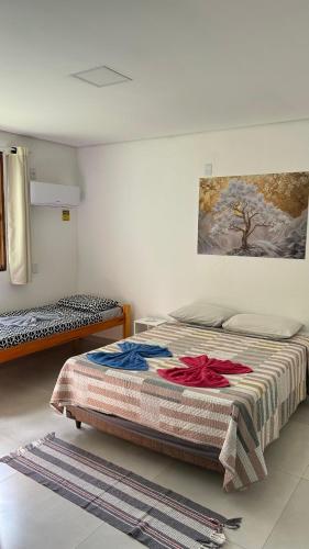 a bedroom with two beds and a painting on the wall at Pousada Cantinho da Mata in Paraty