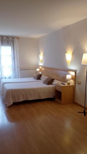 a bedroom with a large bed with two pillows at Hostal Cabrerès in Cantonigros