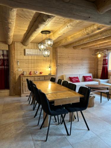 une salle à manger avec une table et des chaises en bois dans l'établissement Chalet des balcons, à Saint-Michel-de-Maurienne