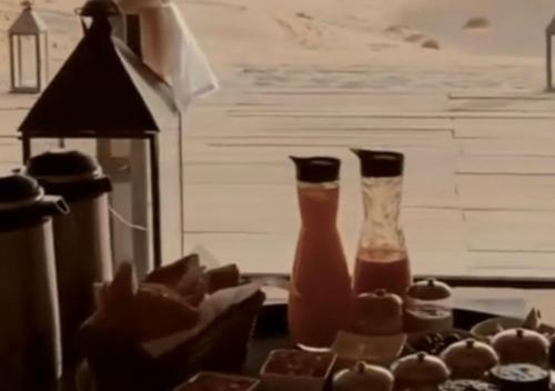 Dos jarrones sobre una mesa con chocolate. en Hayati Desert Luxury Camp, en Merzouga