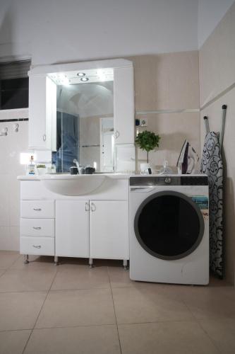 a white kitchen with a sink and a mirror at Vila Brca in Brca