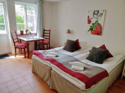 a bedroom with a large bed with a table and chairs at Munkamöllan B&B Skåne Tranås in Skåne-Tranås