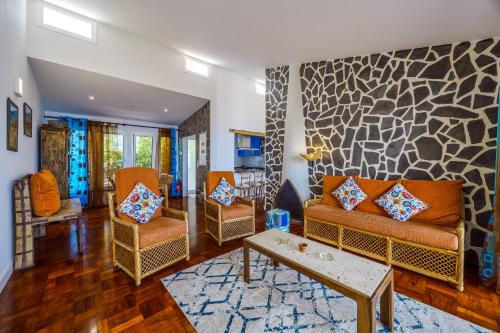 a living room with a couch and two chairs at Casa Maravilha III in Caniço
