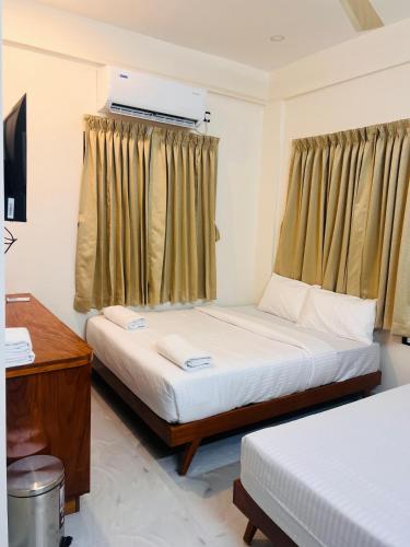 a bedroom with two beds and a window at Vallimony Luxury Stays-Padmanabhaswamy Temple in Trivandrum