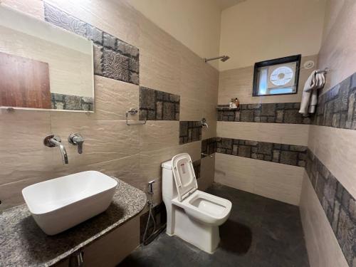 a bathroom with a white toilet and a sink at IRWINA-In rhythm with nature in Pushkar
