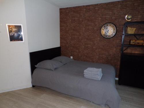 a bedroom with a bed with a clock on the wall at L'aventurier in Jaunay-Marigny